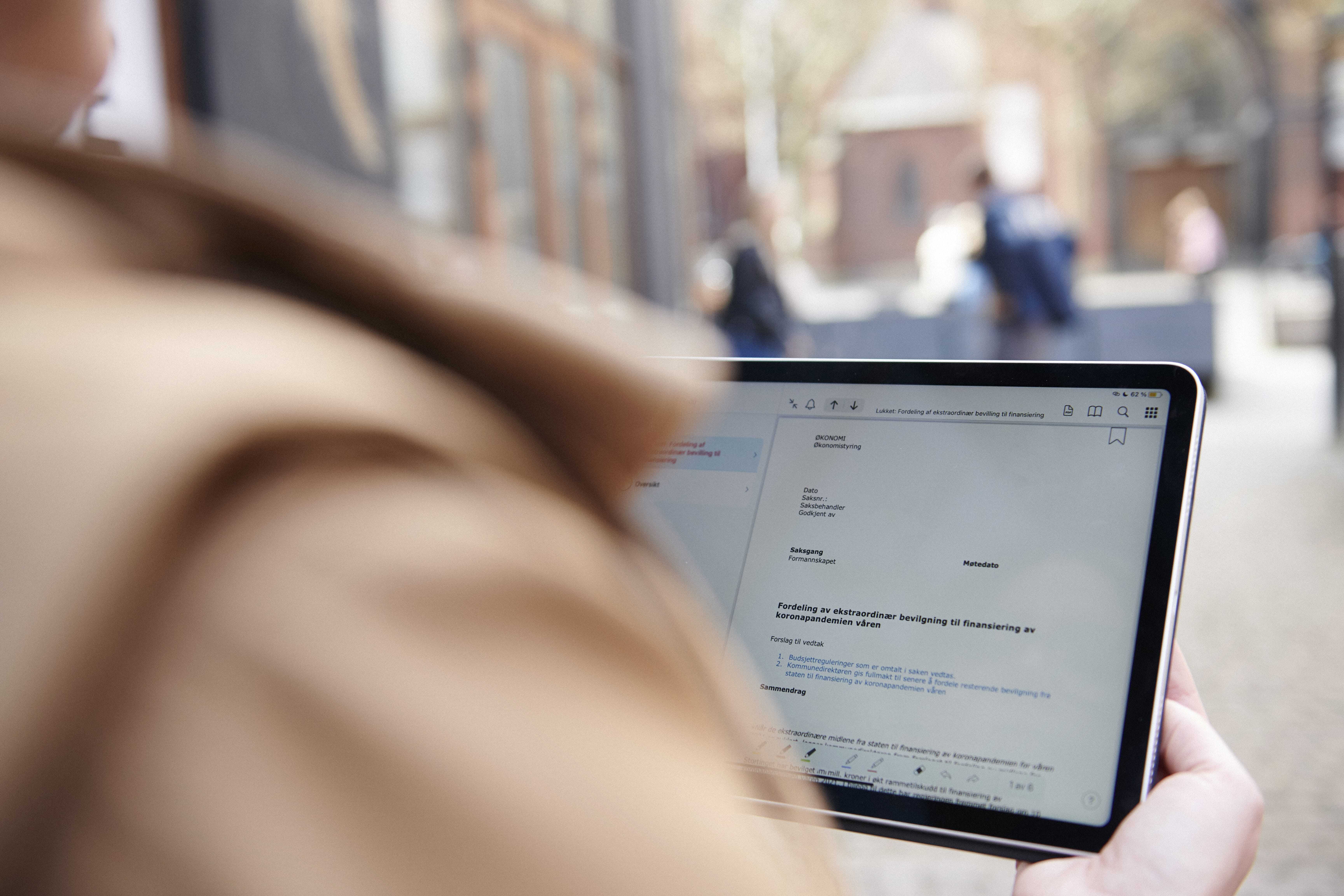 Person læser dokument om digital dokumenthåndtering på tablet